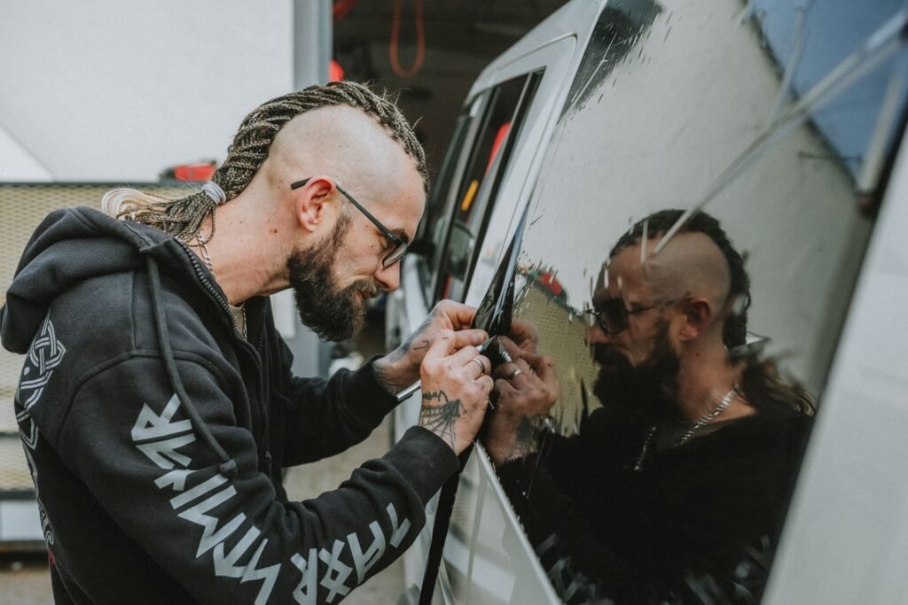 Window tinter trimming film on a van's side window