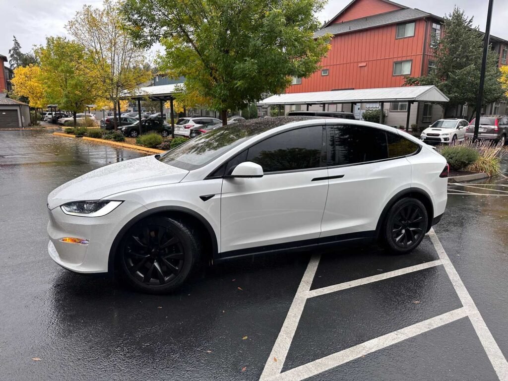 White SUV with tinted side and rear windows parked in the rain