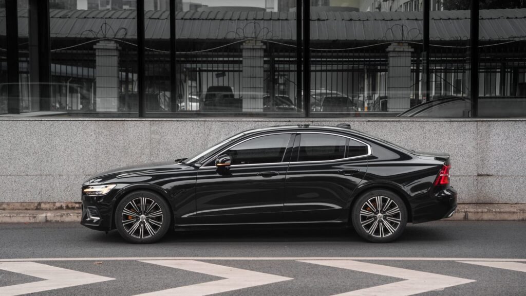 Black sedan with tinted side windows parked beside a granite wall